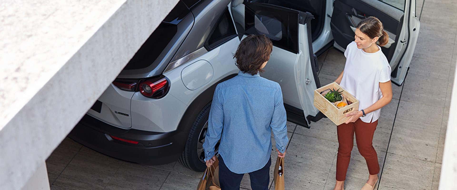 Lancaster Mazda is a Mazda Dealership near York, PA | Birds Eye View of People Carrying Groceries Out of Mazda MX-30 European Model