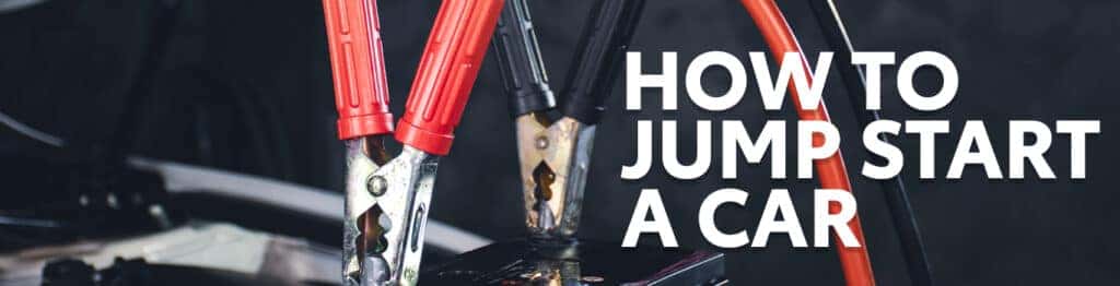 How to Jump Start a Car |  Lancaster Mazda in East Petersburg, PA | Close up of jumper cables attached to car battery with white text on top reading 'How To Jump Start a Car' 