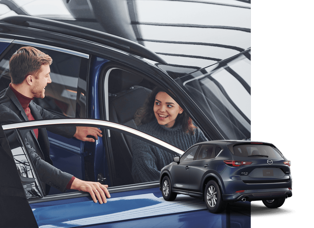 Best Time To Buy At Lancaster Mazda in Lancaster, PA | Woman sitting in the car while smiling and laughing with the sales person standing outside of the car 