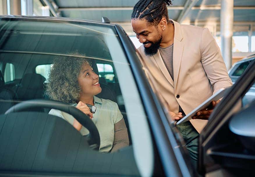 Customer and Sales Advisor Talking While Customer Sits in Vehicle on Sales Room Floor | Leasing versus Buying a Mazda at Lancaster Mazda in Lancaster, PA