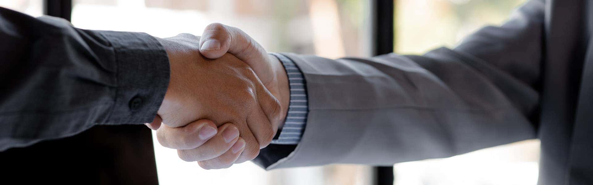 Customer and Sales Advisor Shaking Hands in Dealership Office | Leasing versus Buying a Mazda at Lancaster Mazda in Lancaster, PA