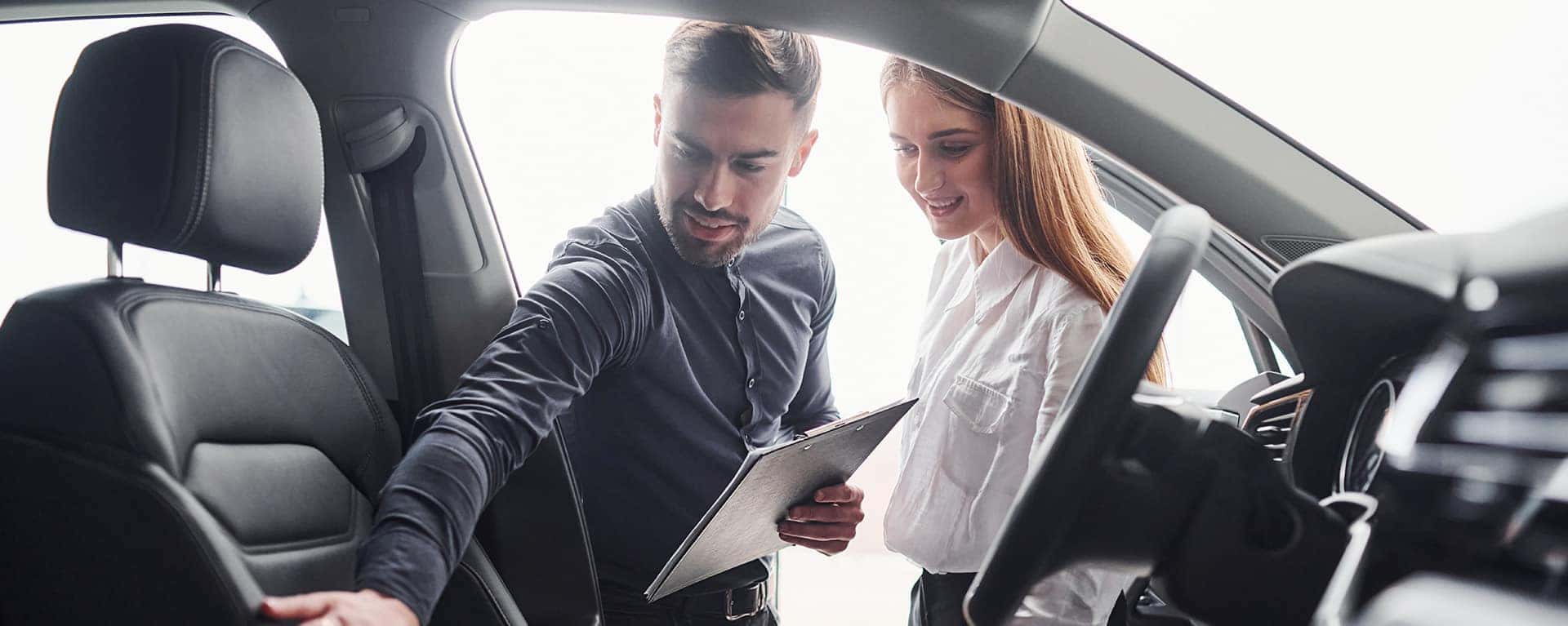 When to Trade In Your Car | Lancaster Mazda in Lancaster, PA | Customer and Saless Advisor Looking at Interior of Vehicle