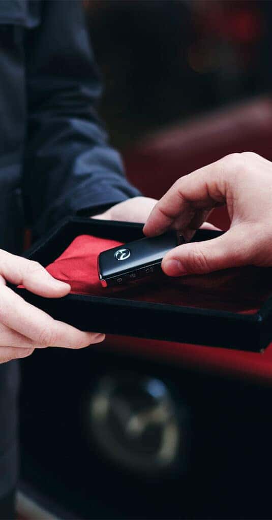 High Cost of Replacing a Car Key | Lancaster Mazda | Service person handing over new replacement keys for their Mazda vehicle 