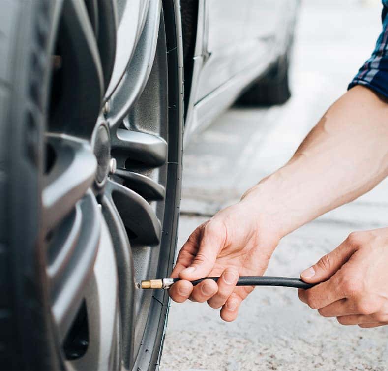 Tire Pressure Information at Lancaster Mazda in East Petersburg, PA | Person putting air into tire using a tire pressure tool
