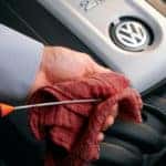 auto mechanic checking dipstick for oil change