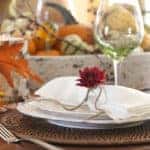 Autumn Thanksgiving holiday dining table place setting with a centerpiece of pumpkins and gourds