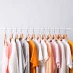 pink, white and orange clothes on a white rack; capsule wardrobe.