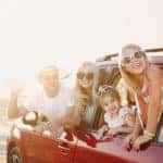 Family smiling at a pitstop during their road trip