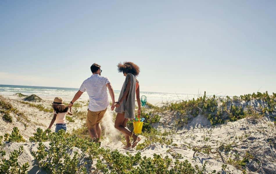 Family headed to the beach with a bucket of toys