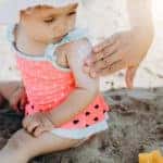 Happy laughing toddler girl having fun on sand
