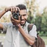 Cheerful men photographer with digital camera