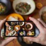 Close up of person taking photo of delicious food with a smartphone.