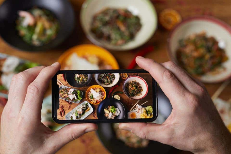 Close up of person taking photo of delicious food with a smartphone.