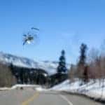 Chipped windshield with road and snow covered mountains