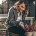 Photo of a young woman taking care of her garden on a beautiful autumn day