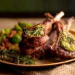 Charcoal grilled rack of lamb chops topped with pesto and rosemary