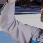 service technician working on raised car