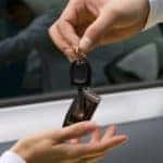 Close up of man handling car keys to woman