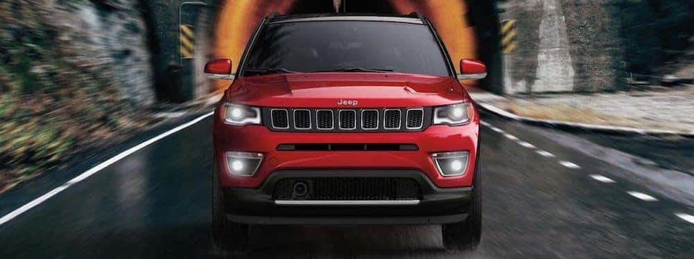 2019 red Jeep Compass driving out of a tunnel