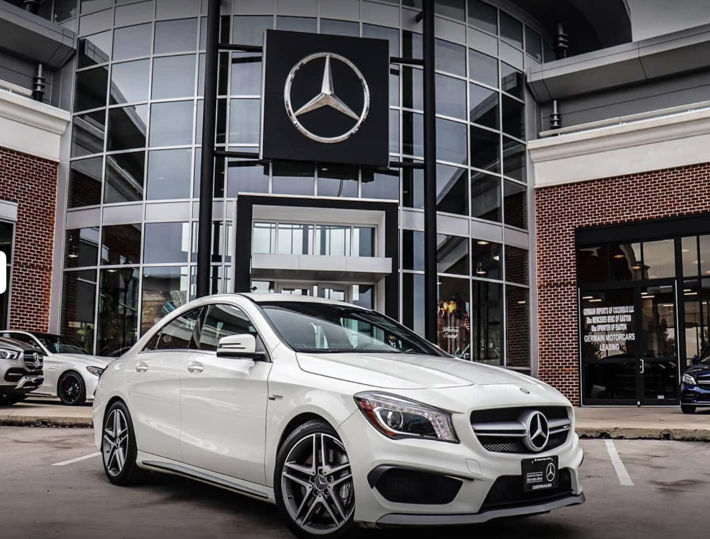 White Mercedes-Benz sedan parked in front of dealership