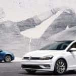 Blue and white Golf hatchbacks parked in lot