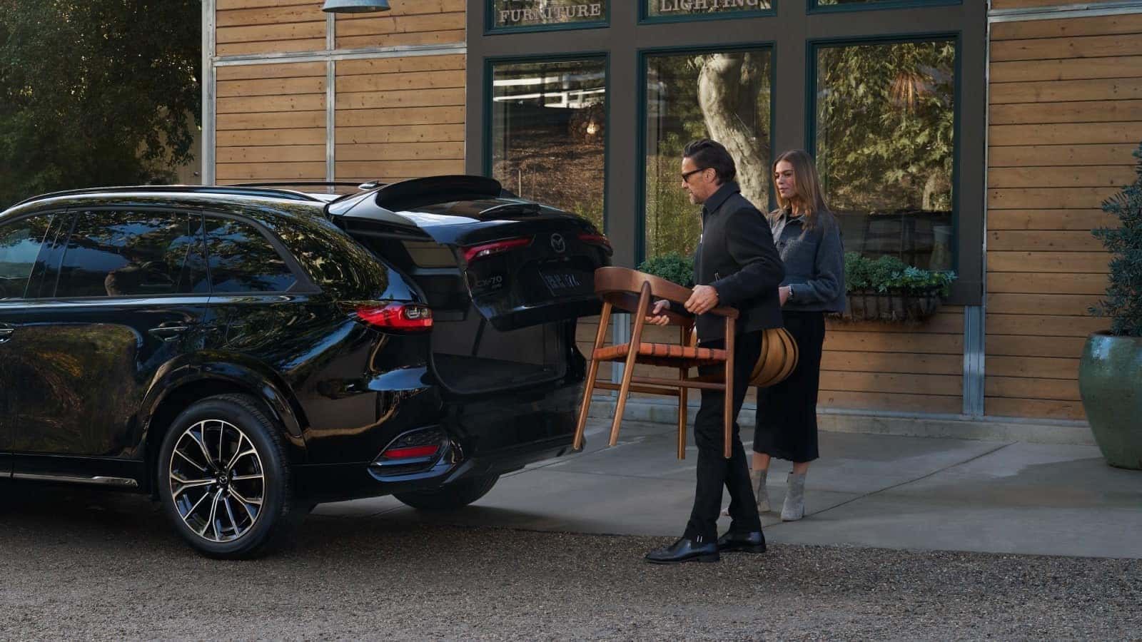 Person loading the cargo area of the 2026 Mazda CX-70