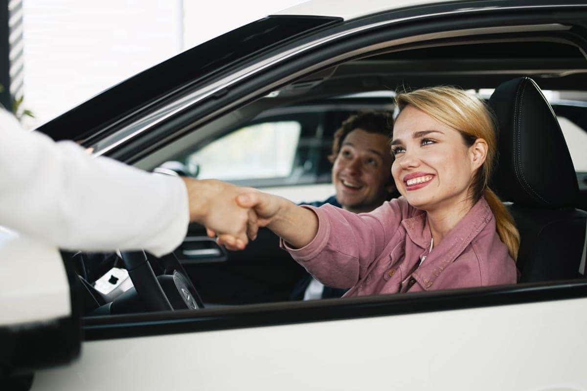 A happy family member feeling satisfied after buying a used car, reflecting a significant investment in their future through a reputable car dealership