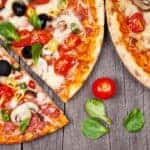 Two pizzas on a gray wood background