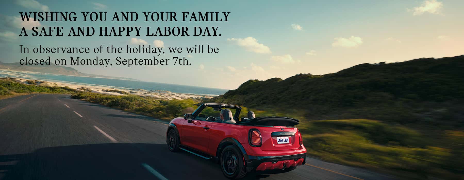 MINI convertible cruising down road.