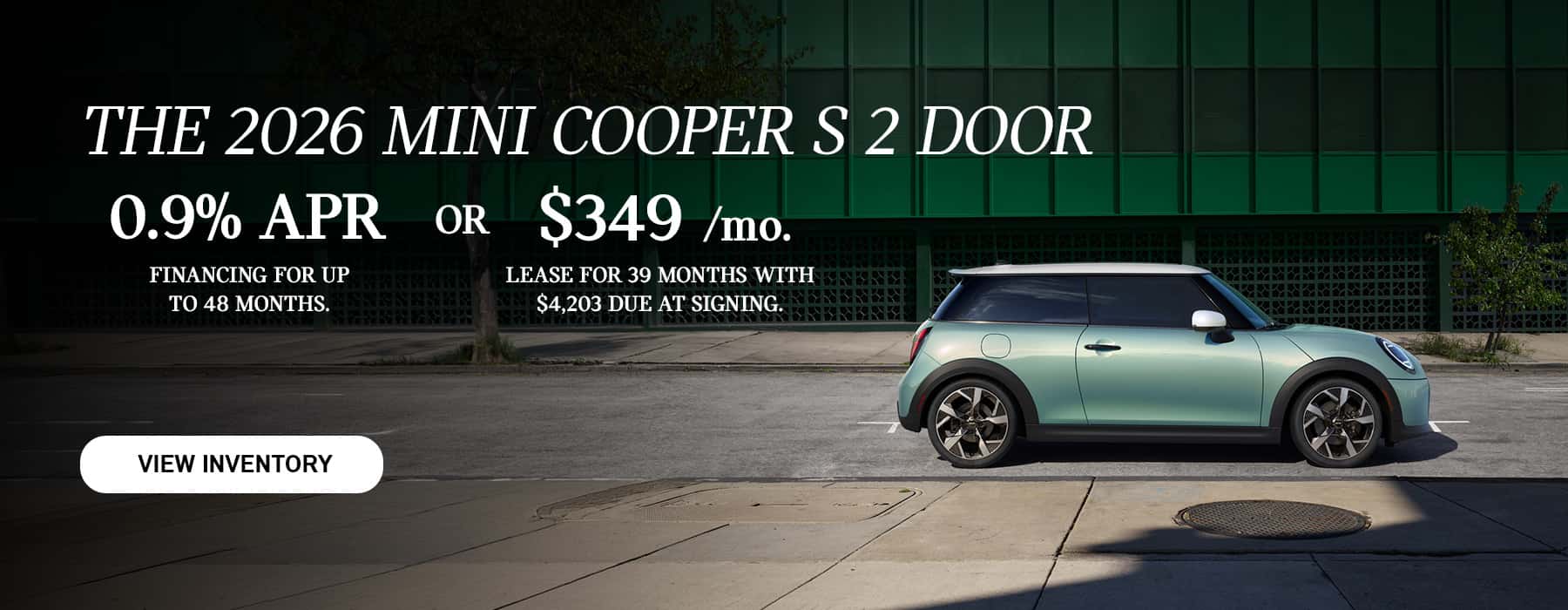 Green MINI 2 Door parked in front of a green building.