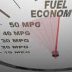 The words Fuel Economy on a vehicle speedometer with a red needle racing past numbers 10, 20, 30, 40, 50 MPG as the automobile achieves an improved efficiency rating as mandated by the government