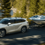 2021 Toyota Highlander Towing Boat on lakeside road