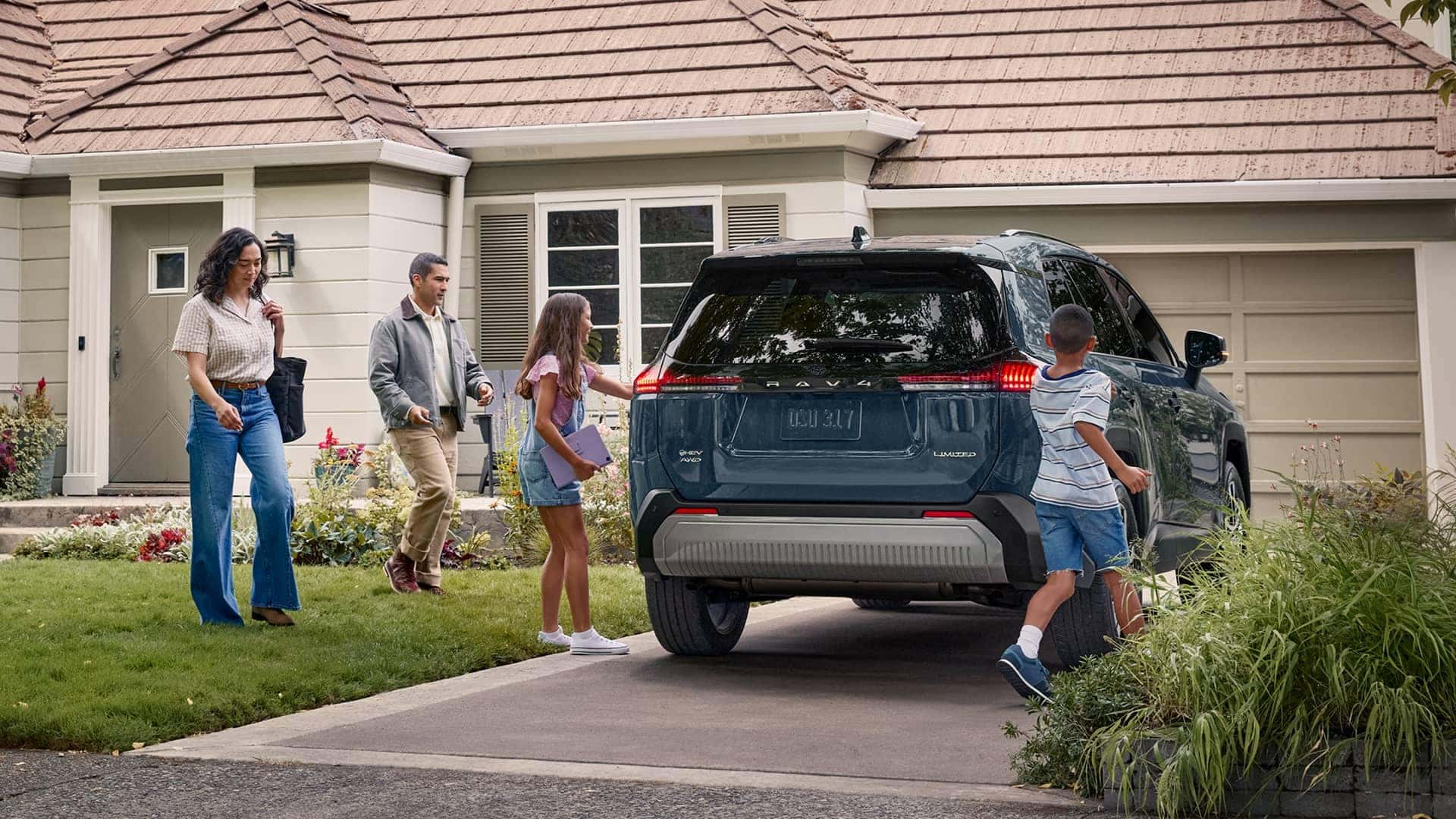 family next to vehicle in driveway