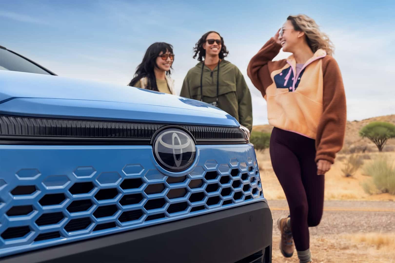 three people standing text to toyota vehicle