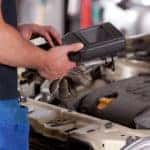 Detail of a mechanic using electrnoic diagnostic equipment to tune a car