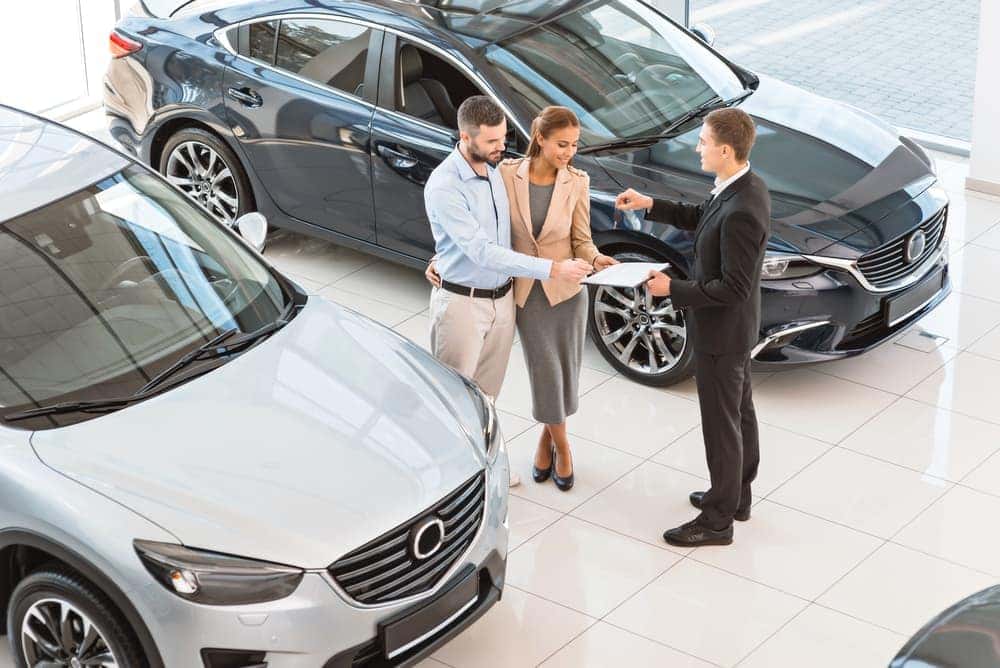 Couple signing documents for new car