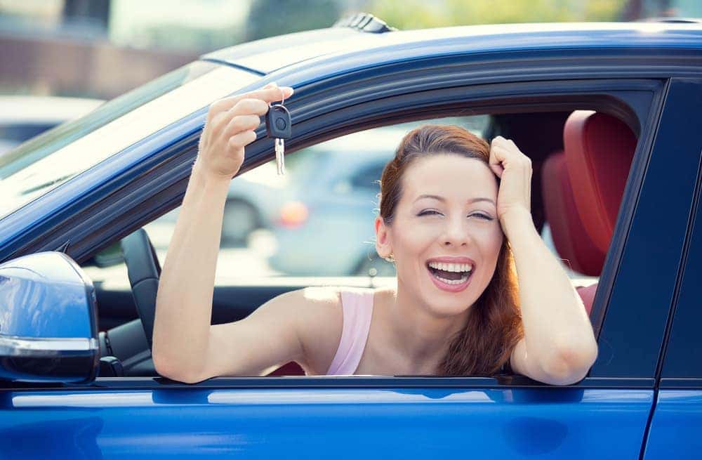 Woman shows car keys sitting in car