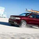 2020 Dodge Durango red heading towards the beach with surf boars strapped to the roof rack