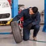mechanic inspecting tire for less thanks to tire warranty