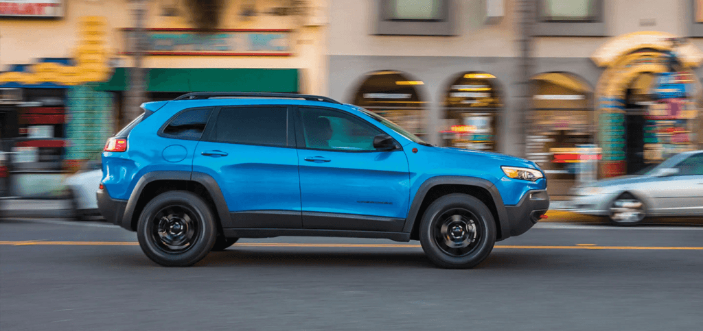 2023 Jeep Cherokee driving down an urban street